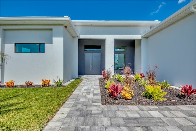 view of exterior entry with a lawn