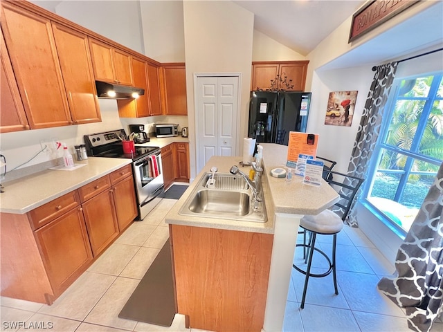 kitchen featuring stainless steel appliances, a breakfast bar, a center island with sink, lofted ceiling, and sink