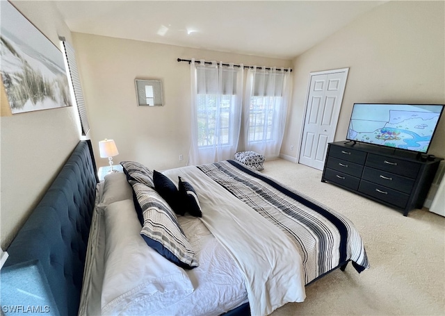 bedroom with light carpet and vaulted ceiling