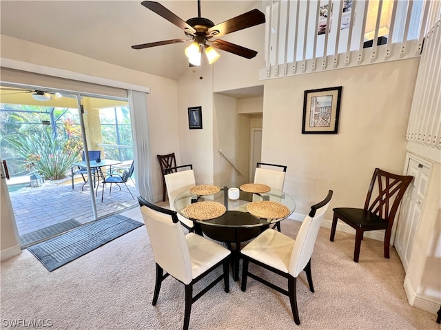 carpeted dining room with ceiling fan and a towering ceiling