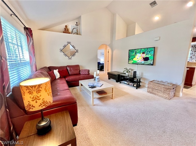 carpeted living room featuring high vaulted ceiling