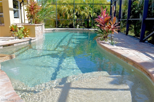 view of swimming pool featuring a patio area, a lanai, and pool water feature