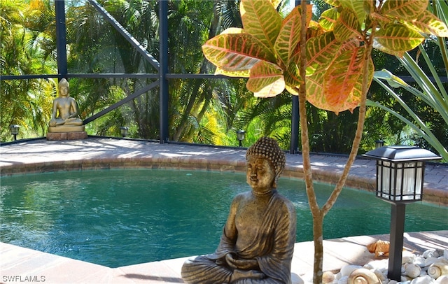 view of swimming pool featuring a lanai