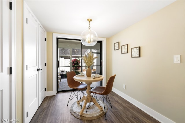 dining area with an inviting chandelier and dark wood-type flooring