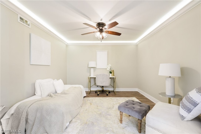 bedroom with ornamental molding, ceiling fan, and light hardwood / wood-style flooring