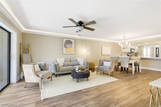 living room with light wood-type flooring and ceiling fan with notable chandelier