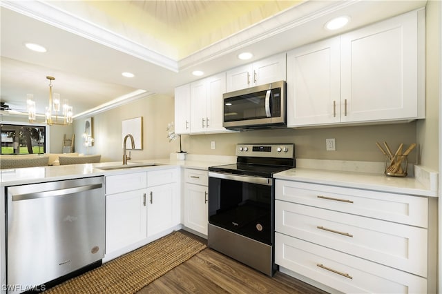 kitchen with sink, crown molding, dark hardwood / wood-style flooring, appliances with stainless steel finishes, and a notable chandelier