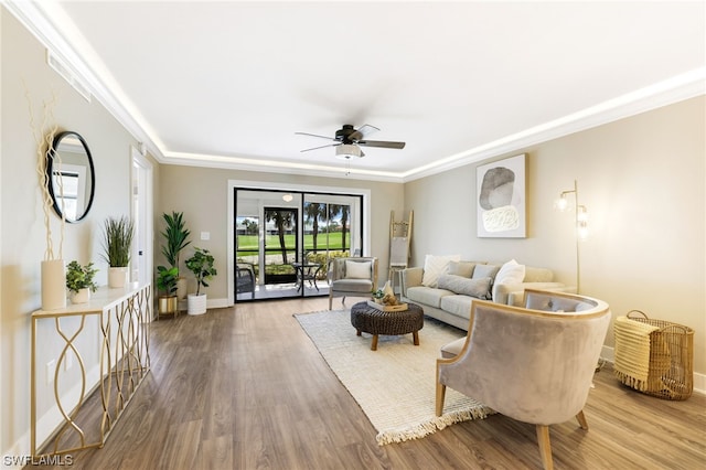 living room featuring ornamental molding, wood-type flooring, and ceiling fan