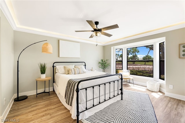 bedroom featuring ornamental molding, ceiling fan, and light wood-type flooring