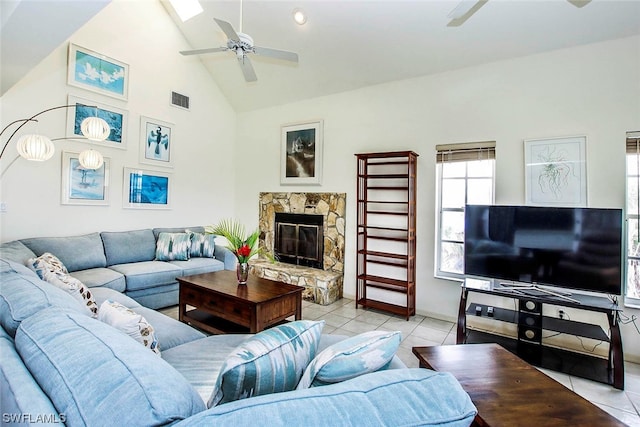 living room with high vaulted ceiling, a fireplace, ceiling fan, and light tile floors