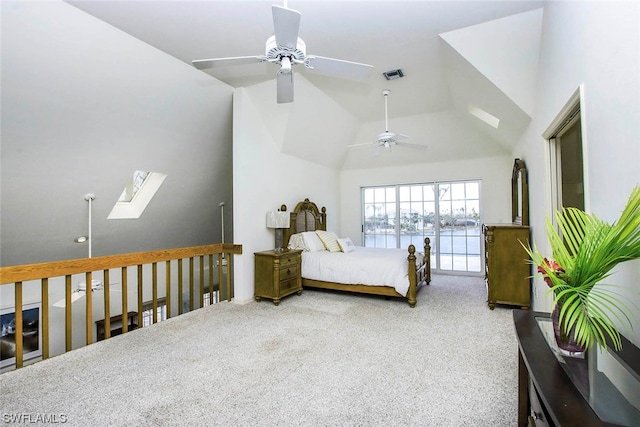 carpeted bedroom with vaulted ceiling with skylight and ceiling fan