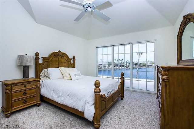 bedroom with ceiling fan, access to outside, vaulted ceiling, light carpet, and a water view