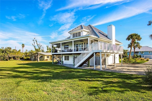 rear view of house featuring a yard and a wooden deck