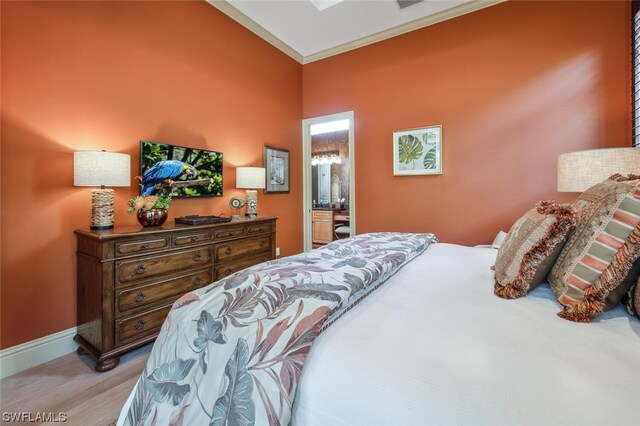 bedroom with ornamental molding and ensuite bathroom