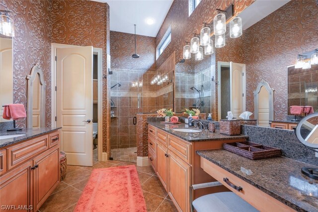 bathroom with tile patterned floors, toilet, a shower with shower door, and vanity