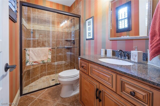 bathroom featuring an enclosed shower, vanity, tile patterned floors, and toilet