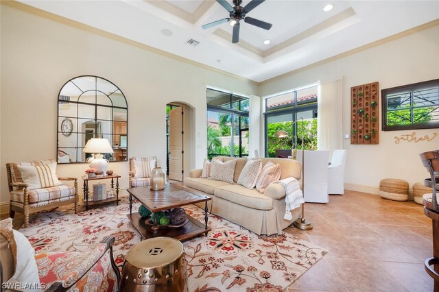 tiled living room with crown molding, a towering ceiling, and ceiling fan