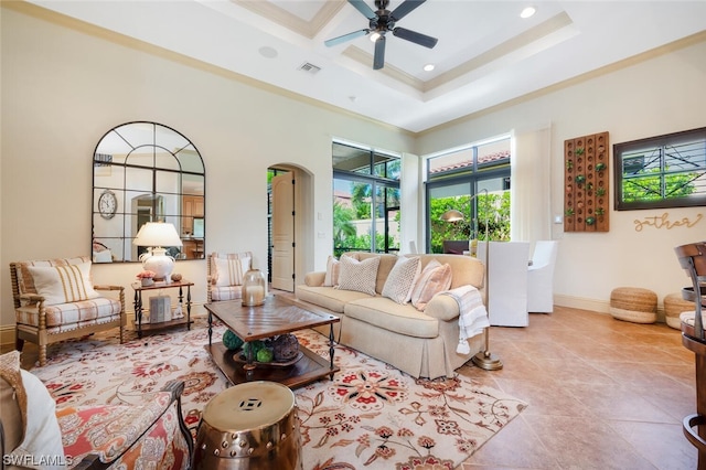 tiled living room featuring crown molding, ceiling fan, and a high ceiling