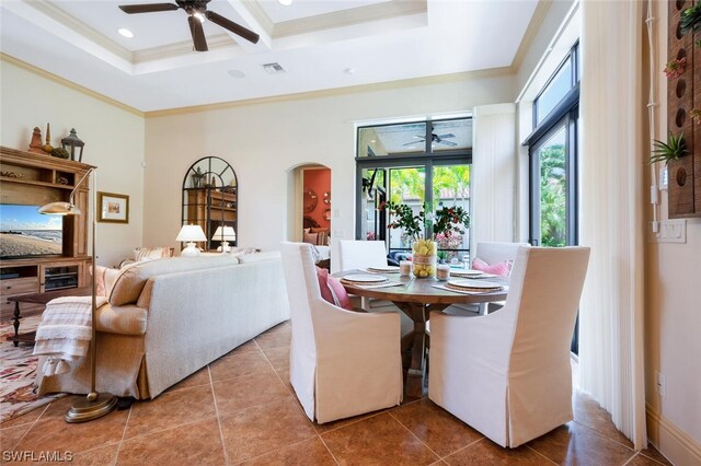 dining space featuring a towering ceiling, coffered ceiling, ceiling fan, crown molding, and tile patterned floors