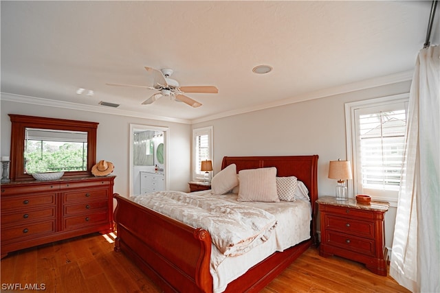 bedroom featuring connected bathroom, wood-type flooring, ceiling fan, and ornamental molding