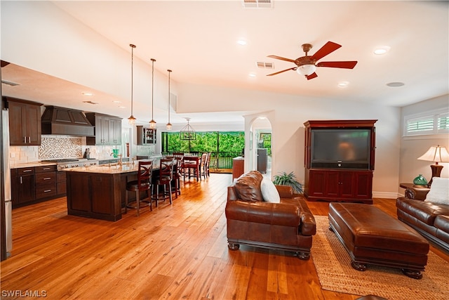 living room featuring light hardwood / wood-style floors, ceiling fan, and a wealth of natural light