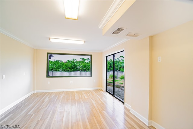 empty room featuring ornamental molding and light hardwood / wood-style flooring