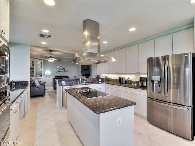 kitchen featuring island range hood, sink, white cabinets, black electric stovetop, and stainless steel fridge with ice dispenser