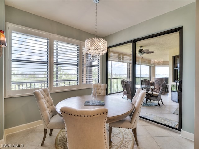 dining space with light tile patterned floors and ceiling fan with notable chandelier