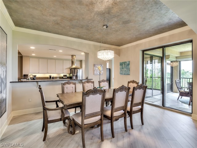 dining space featuring ornamental molding, an inviting chandelier, and light wood-type flooring