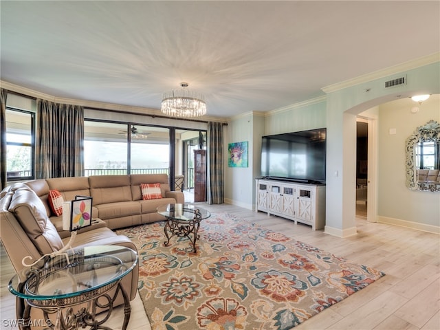 living room featuring ornamental molding, an inviting chandelier, and light wood-type flooring