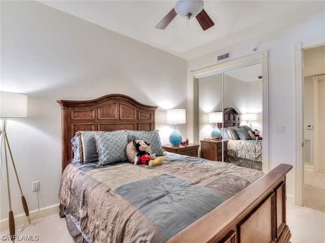 carpeted bedroom with ceiling fan and a closet