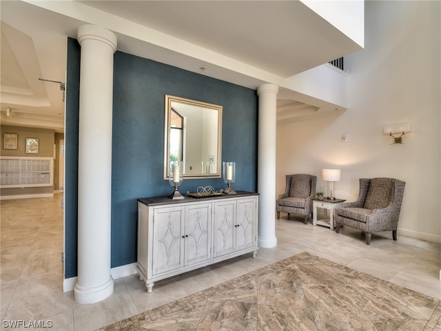 living area with light tile patterned flooring and ornate columns