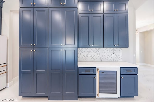 kitchen featuring backsplash, wine cooler, and blue cabinetry