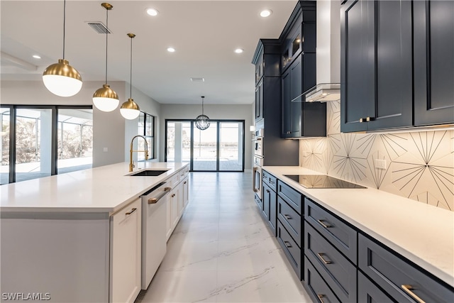 kitchen with black electric stovetop, wall chimney exhaust hood, decorative light fixtures, backsplash, and sink