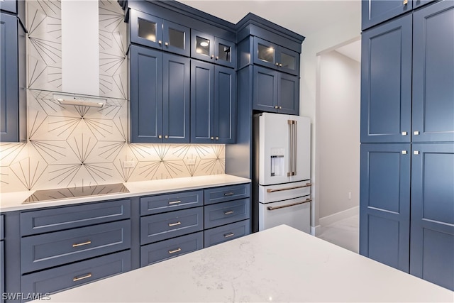 kitchen with blue cabinetry, high end white fridge, and backsplash