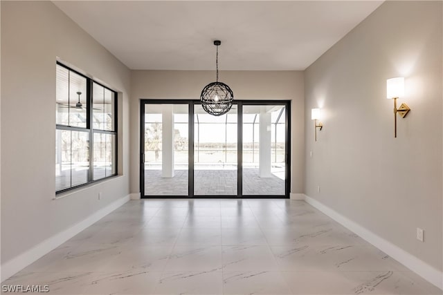 tiled empty room featuring a notable chandelier