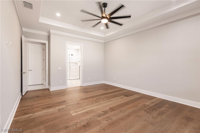 unfurnished room featuring hardwood / wood-style floors, ceiling fan, and a raised ceiling