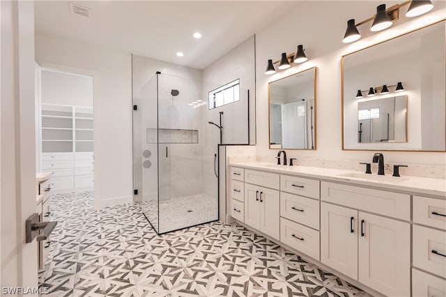 bathroom with double vanity, an enclosed shower, and tile flooring