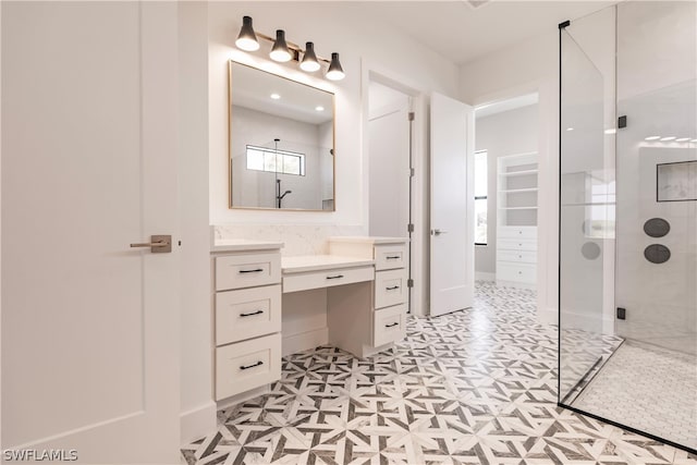 bathroom with a shower with shower door, tile flooring, and vanity