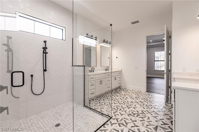 bathroom featuring tile flooring, an enclosed shower, and double sink vanity