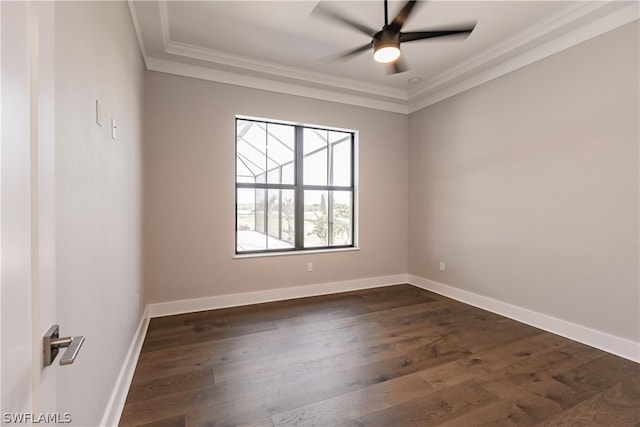 spare room featuring ornamental molding, dark hardwood / wood-style floors, ceiling fan, and a raised ceiling