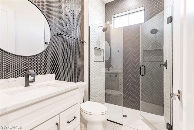 bathroom with a shower with shower door, tile walls, toilet, and large vanity