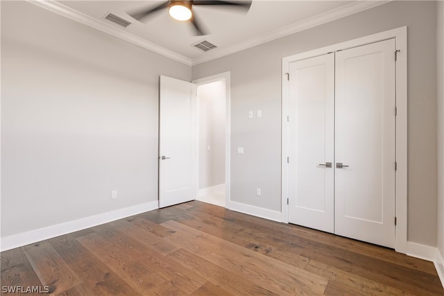 unfurnished bedroom featuring crown molding, hardwood / wood-style flooring, a closet, and ceiling fan