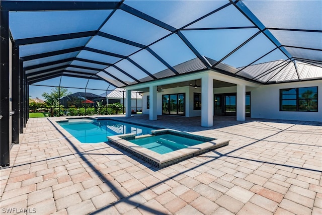 view of swimming pool featuring ceiling fan, glass enclosure, an in ground hot tub, and a patio