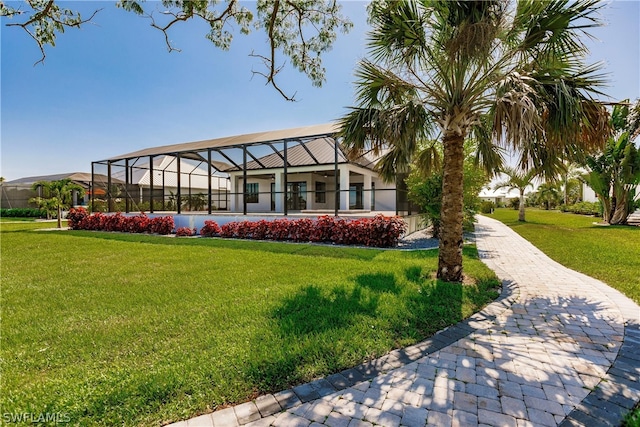 view of front of home featuring a front lawn and glass enclosure