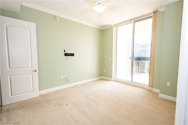 empty room with ceiling fan, light colored carpet, ornamental molding, and expansive windows