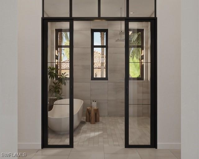 bathroom with a washtub and french doors