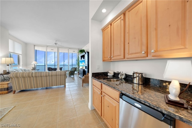 kitchen featuring a wall of windows, sink, ceiling fan, dark stone countertops, and dishwasher