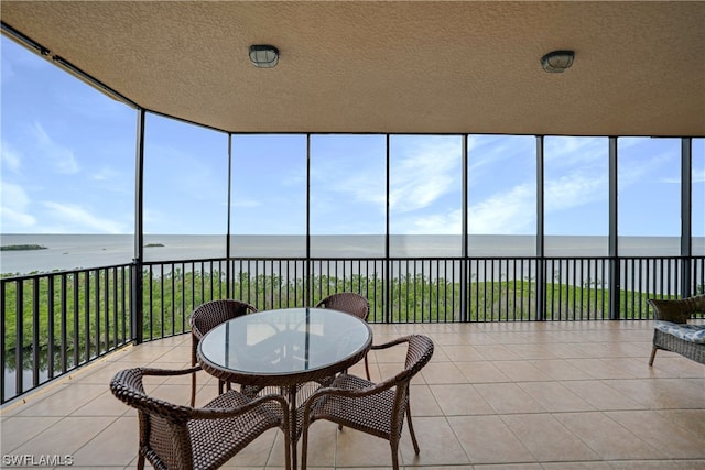 sunroom / solarium featuring a water view