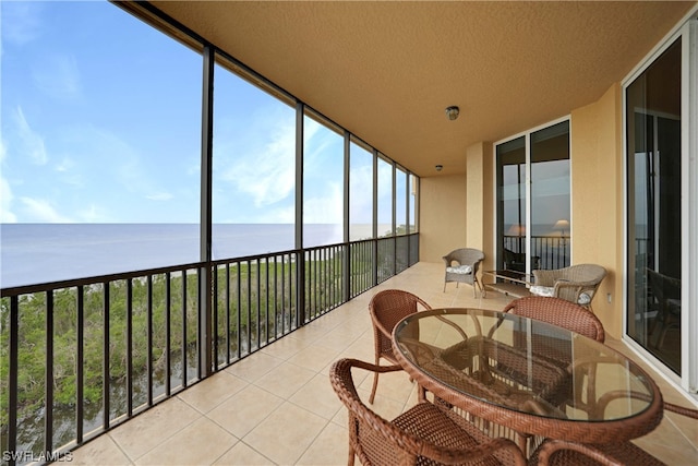 sunroom featuring a water view